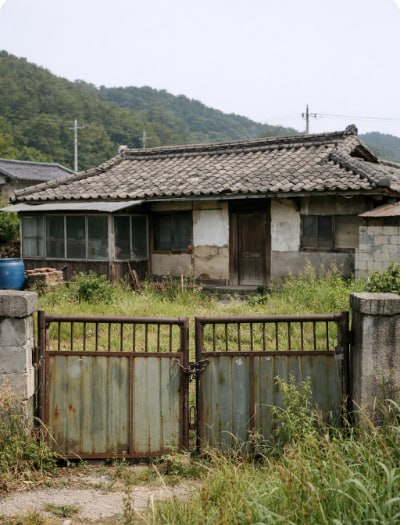 잡초가 자란 마당과 낡은 대문이 보이는 농촌 빈집 대표 이미지